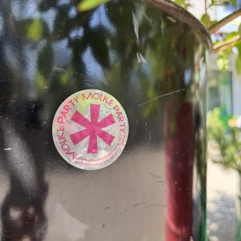 Silbriger Sticker mit pinkem Aufdruck: Grosser Genderstern und rundherum Text: «Molke Party» – Eine Welt der Milchjugend – instagram.com/milchjugend
