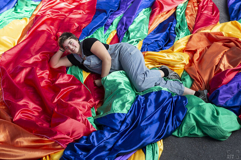 Queere Person auf Regenbogenfahne